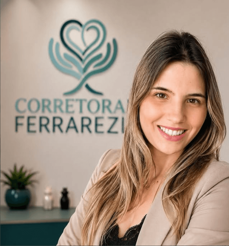Gabriela, corretora da Ferrarezi, em frente ao logo da empresa